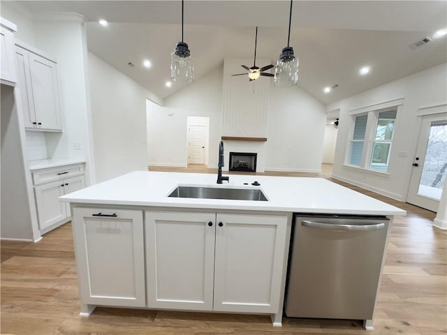 kitchen featuring sink, white cabinets, dishwasher, and a kitchen island with sink