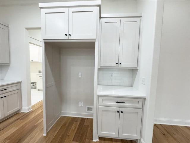 kitchen featuring white cabinets, hardwood / wood-style floors, and tasteful backsplash