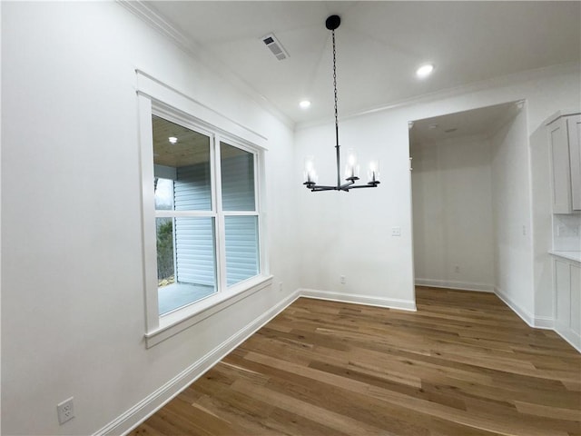 unfurnished dining area featuring baseboards, wood finished floors, and ornamental molding