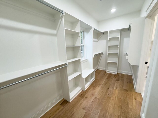 spacious closet with light hardwood / wood-style flooring