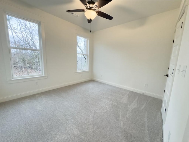 carpeted spare room featuring ceiling fan and a healthy amount of sunlight