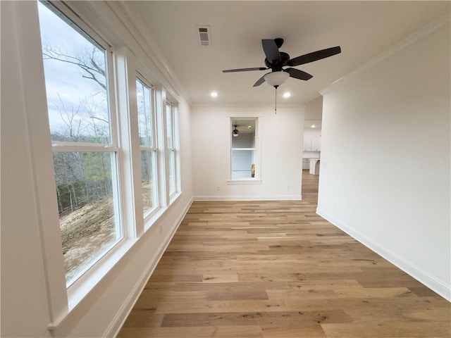 unfurnished sunroom featuring ceiling fan and visible vents