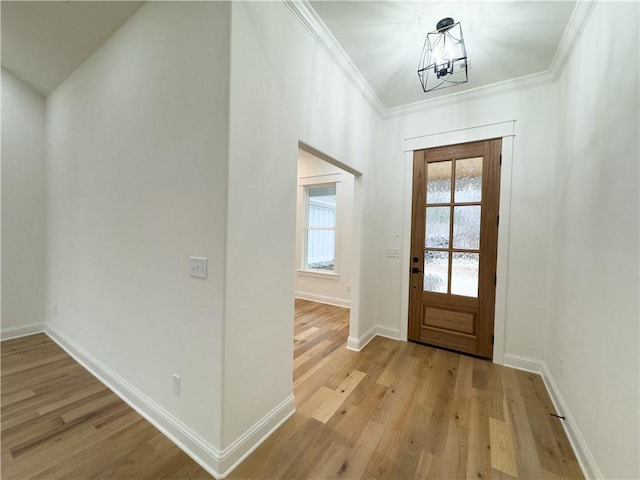 entryway with crown molding, a chandelier, and light hardwood / wood-style flooring