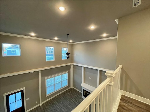 interior space with wood-type flooring, ceiling fan, and ornamental molding