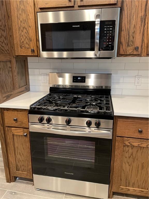 kitchen with decorative backsplash and appliances with stainless steel finishes