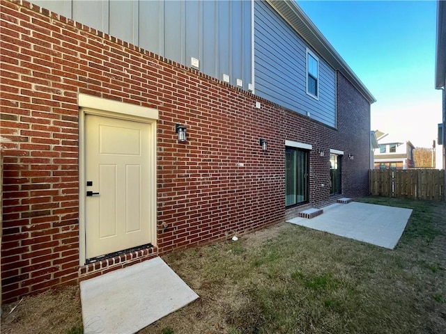 rear view of house featuring a lawn and a patio