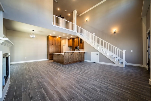 unfurnished living room featuring ornamental molding and a high ceiling