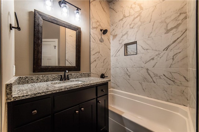 bathroom featuring vanity and tiled shower / bath