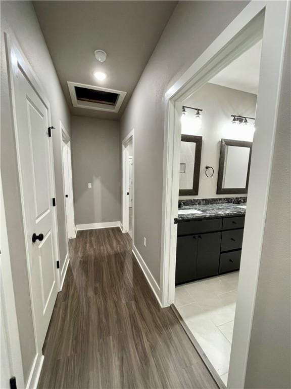 corridor with dark hardwood / wood-style flooring and sink