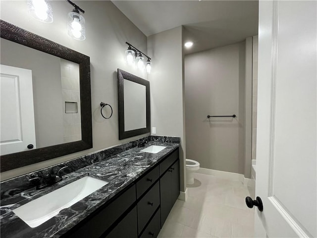 bathroom with tile patterned flooring, vanity, and toilet