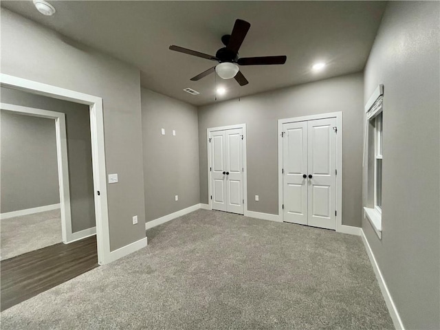 unfurnished bedroom with dark colored carpet and ceiling fan