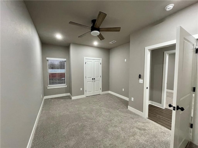 carpeted spare room featuring ceiling fan