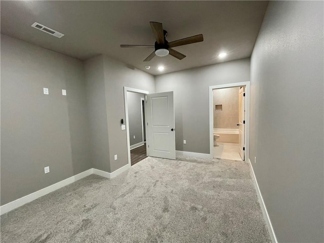 unfurnished bedroom featuring carpet flooring, ensuite bath, and ceiling fan