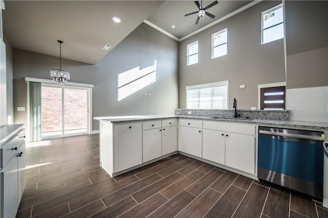 kitchen featuring dishwasher, kitchen peninsula, white cabinetry, and sink