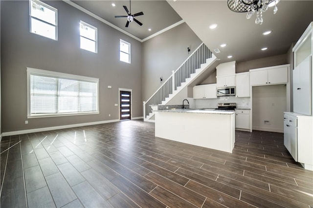 kitchen with white cabinetry, plenty of natural light, an island with sink, and appliances with stainless steel finishes