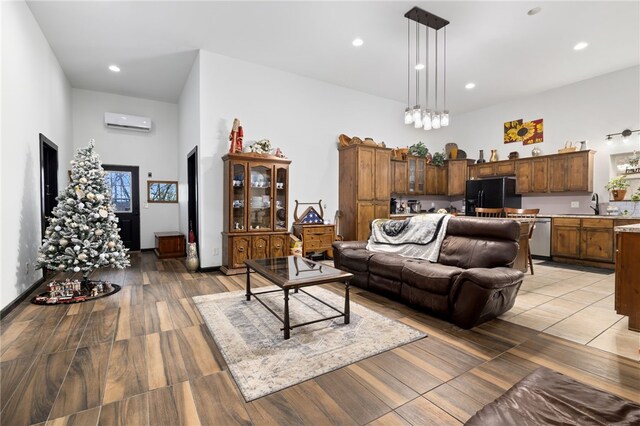 living room featuring sink, wood-type flooring, and a wall mounted air conditioner