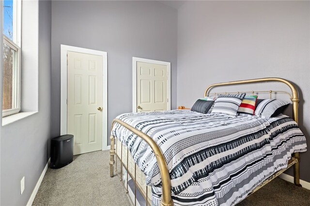 bedroom with light colored carpet and a high ceiling