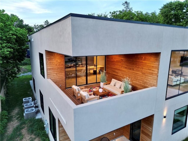 back of property featuring an outdoor living space and stucco siding