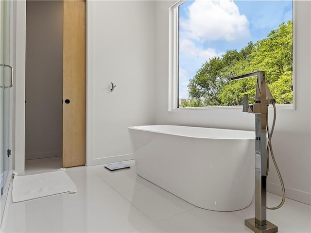 bathroom featuring tile patterned floors and a bath