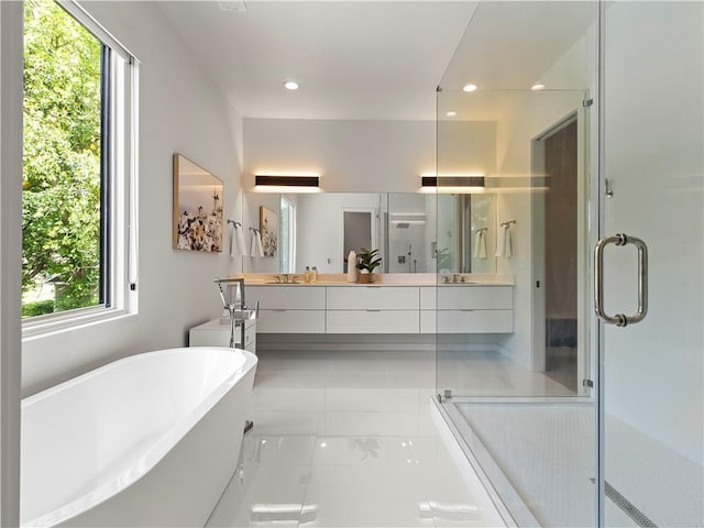 full bathroom with double vanity, recessed lighting, a freestanding tub, and a shower stall