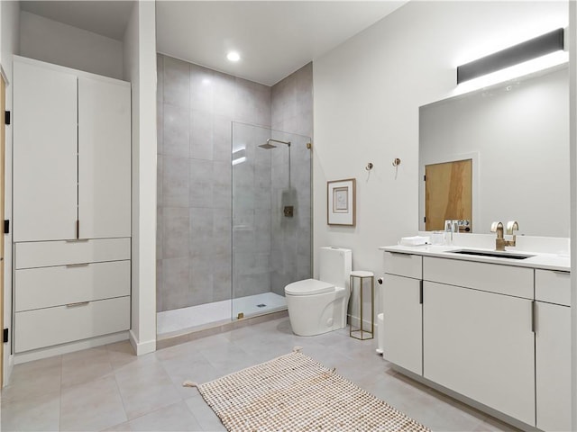 bathroom with a stall shower, vanity, toilet, and tile patterned floors