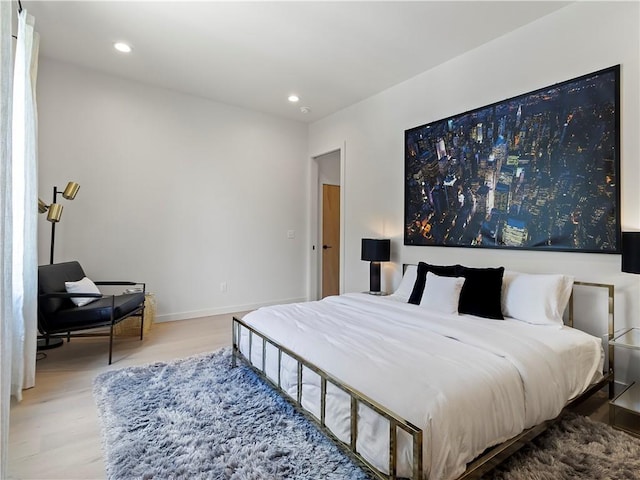 bedroom featuring baseboards, wood finished floors, and recessed lighting