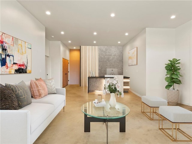 living area featuring recessed lighting, concrete floors, and baseboards