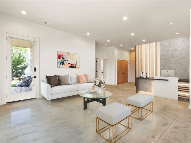 living area with finished concrete floors, visible vents, and recessed lighting