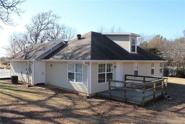 rear view of property featuring a lawn and a deck