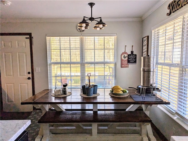 dining room featuring a healthy amount of sunlight, crown molding, and an inviting chandelier