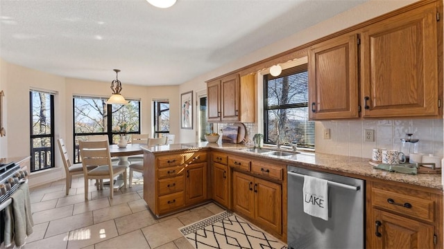 kitchen featuring stainless steel dishwasher, plenty of natural light, backsplash, and brown cabinets