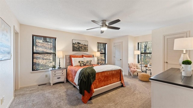 bedroom featuring carpet floors, a ceiling fan, visible vents, and baseboards