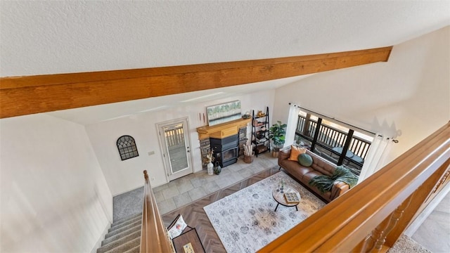 living area featuring a wood stove, stairs, lofted ceiling with beams, and a textured ceiling