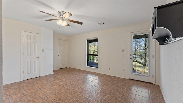 spare room with ceiling fan and visible vents