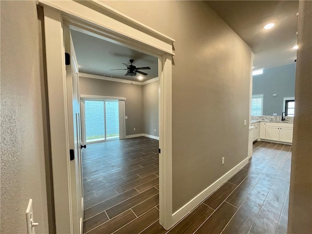 corridor with sink and crown molding