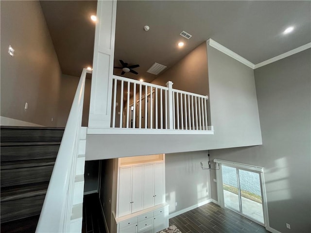 stairway featuring ceiling fan and ornamental molding