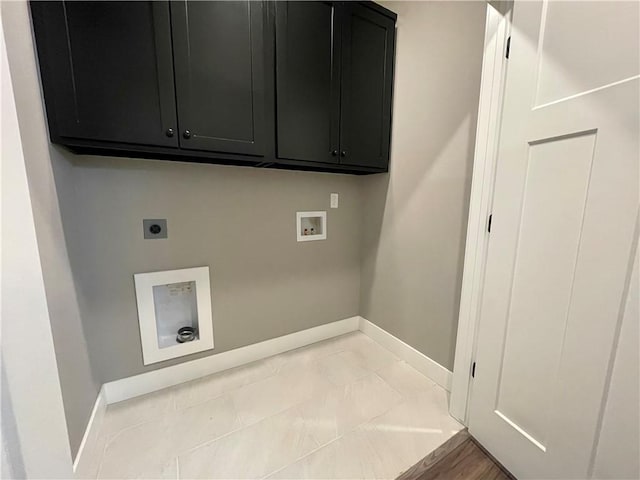 clothes washing area with hookup for an electric dryer, washer hookup, and cabinets