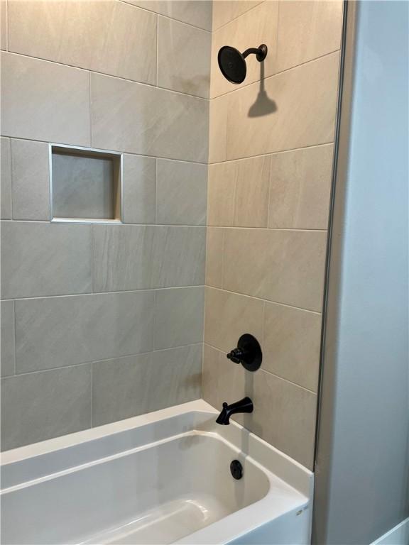 bathroom with tiled shower / bath combo