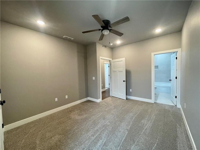 unfurnished bedroom featuring carpet flooring, ensuite bathroom, and ceiling fan