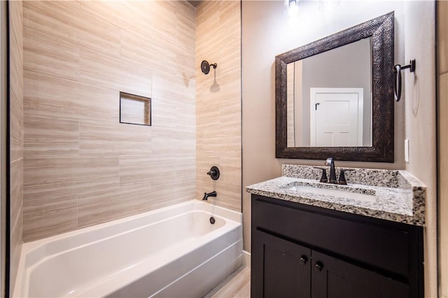 bathroom featuring vanity and tiled shower / bath