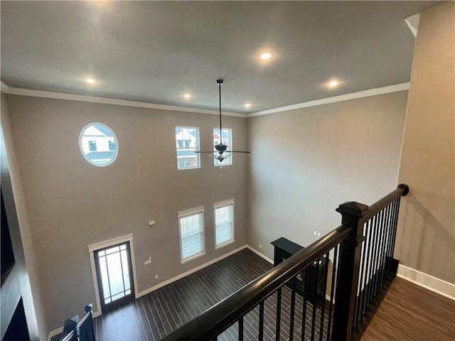 staircase with hardwood / wood-style floors, ceiling fan, and crown molding