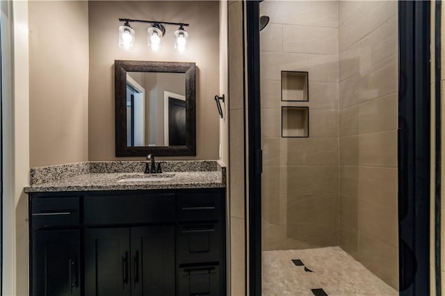 bathroom with vanity and tiled shower