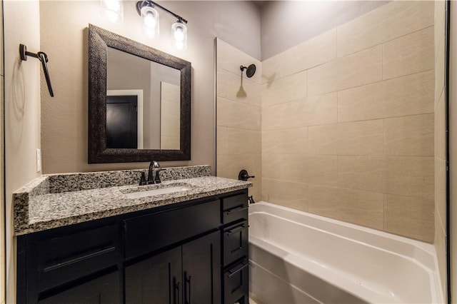 bathroom featuring vanity and tiled shower / bath