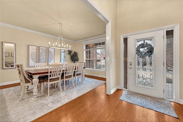 dining room with wood-type flooring, crown molding, and a chandelier