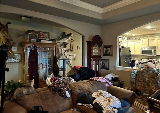 living room with a raised ceiling and crown molding