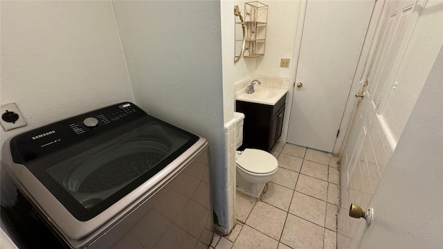 bathroom featuring tile patterned floors, toilet, vanity, and washer / dryer