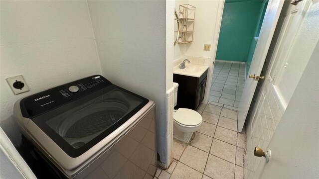 bathroom featuring tile patterned floors, vanity, toilet, and washer / dryer