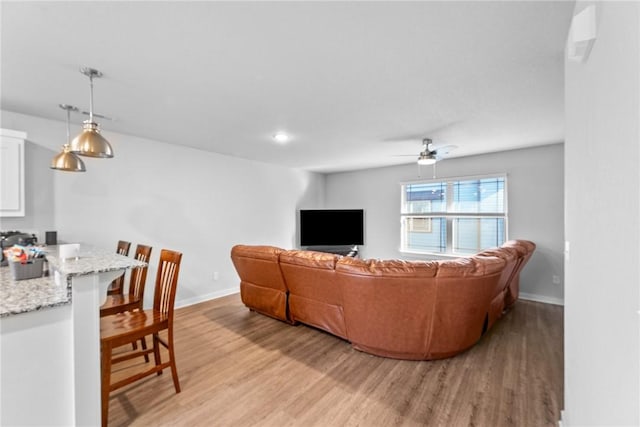 living room featuring ceiling fan and light wood-type flooring