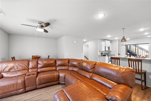 living room featuring ceiling fan and light wood-type flooring