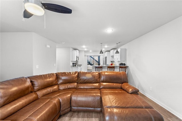 living room featuring ceiling fan and hardwood / wood-style flooring